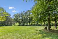 The backyard is completely enclosed by trees, providing privacy while still offering stunning views of over 200 feet along the 6th hole.