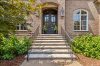 Stunning gas lamps flank the front entryway leading to the 11’ custom iron doors with upgraded hardware.