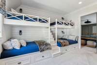 This cozy bunk room features two twin bunks and two full-size bunks, complete with center stairs and individual lights and charging stations for convenience.