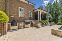 This inviting brick outdoor kitchen is equipped with a 42” built-in Alfresco grill, perfect for entertaining and enjoying outdoor cooking.