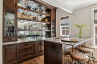 The bar features a 72-inch Perlick back bar refrigerator, ICE-O-MATIC sonic ice machine, walk-in custom walnut wine room with smoked glass and floating walnut shelves, along with a hand-hammered copper sink and leathered granite counter.