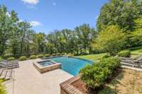 A captivating grotto, measuring 9’ 6” x 8’ 6”, features a copper scupper waterfall entry, built-in seating, and deep water, all covered by a beautiful waterfall for a serene escape.