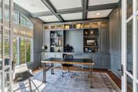 The custom built-ins in the private study feature full-wall molding, while the upper cabinets are enhanced with custom pewter mesh and backlighting.