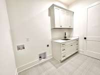 Laundry room with cabinets and built-in sink. ACTUAL HOME UNDER CONSTRUCTION - Same plan as Pasadena Model Home. ALL photos of similar homes & NOT actual home.