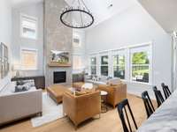 Living room with lots of natural light, vaulted ceiling and custom concrete finished fireplace.