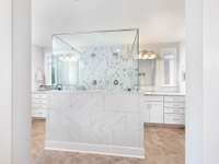 Primary bath features dual vanities and deluxe double shower.