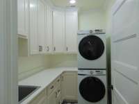 Laundry with deep sink.  Quartz counter top tilled floor and 36 inch door.