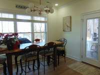 Door to patio and kitchen table set with lake view.