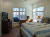 Bedroom #2 SE corner with lake view and door to covered patio. Cedar lined closet.