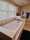 Ceramic tile surround the tub.