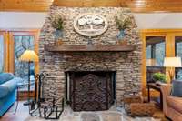 This gorgeous stacked stone, wood-burning fireplace makes this room cozy for family gatherings in the colder months.