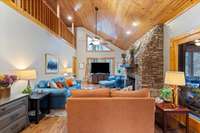 Living room features natural wood-paneled ceilings, tons of natural light, and wood burning fireplace.