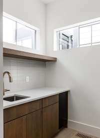 wet bar off the kitchen complete with ice maker and bar sink