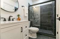 The newly finished 4th bathroom has all new tile, large shower with charcoal tile and glass door.