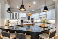 Note the 4 metal wire mesh cabinet doors. Unlike new construction, all appliances convey, including the refrigerator.  The plan is wide open from the kitchen to the breakfast room and family room. It's picture perfect and Instagram worthy.