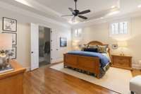 Primary bedroom is tucked in the back of the home for privacy and offers trey ceiling and hardwood floors.