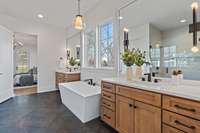 Large soaking tub and double vanities in primary suite.