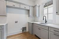 Downstairs Laundry Room with cabinets and sink.