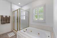 Garden tub and separate shower in large primary bathroom.