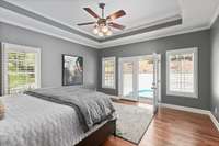 French doors in the primary suite open onto the pool and patio area.