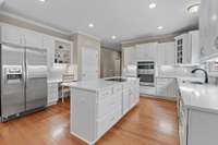 The kitchen has just gotten a total overhaul with new white painted cabinets, new quartz counters, new backsplash, new oven + microwave + cooktop and new lighting.