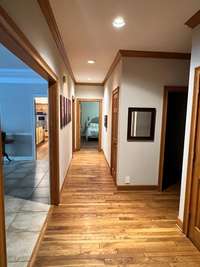 Hallway leading to the two other downstairs bedroom along with the formal Dining room, Kitchen, breakfast nook, hall bath, and giant bonus room.