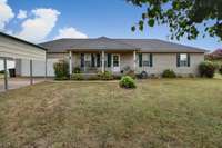 Front of house- concrete driveway & sidewalk, covered front porch, simple landscaping