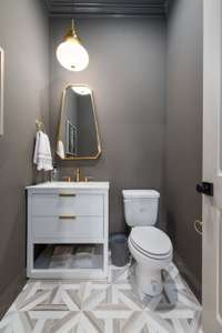 Step into a space where style meets functionality—the powder bath. Tucked away on the main level of the home, this petite yet elegant bathroom offers a convenient respite for guests that's both inviting & chic.