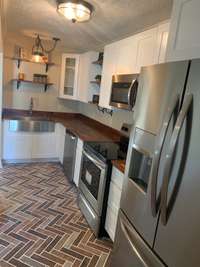 Enjoy newer stainless appliances, plenty of cabinet space, and an adorable tile brick floor!