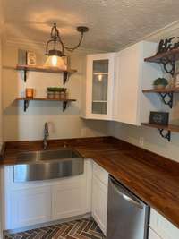 The kitchen has modern finishes with a farm-house sink and warm counter tops!