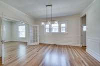 Another view of the dining room with picture frame molding and passage to kitchen.