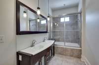 Master bath with tub/shower combo and dual vanities.