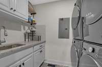 Decorative floor tile, sink and countertop and cabinets. Everything you need in a laundry room.