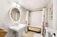 The full bathroom in the basement features another vintage tub that was recently reglazed, in addition to the penny tile.