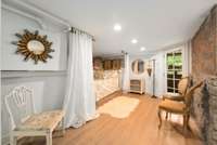 This bedroom is generously sized and features a walk-in closet and charming stone wall.