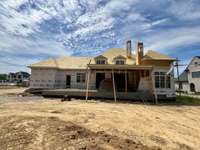 View of rear elevation and over-the-top outdoor living features. Huge backyard offers plenty of space  for a pool and outdoor activities. *this home is under construction  Photo Taken 8/14/24