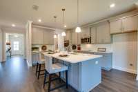 Lovely eat in Kitchen with quartz counters.  Includes cook top with SS vent hood, double ovens, microwave in Island.