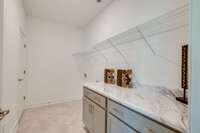 Huge Laundry room with folder countertop and storage cabinets.