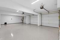 3 car garage with epoxy flooring and additional storage area