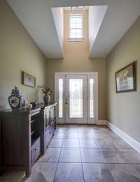 Large ceramic tile foyer area with window and arched widow.