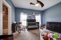 Carpeted 3rd bedroom with lighted, very decorative ceiling fan.