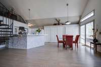 Eating area, kitchen, and storage cabinets. Lots of light shinning in through the door, transoms, etc.