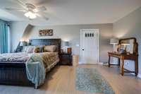 Bedroom in Barndominum with lighted ceiling fan.