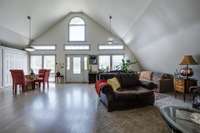 Interior of Barndominium. Very open layout with lots of light through windows, doors, and transoms. Check out the arched window above the door.