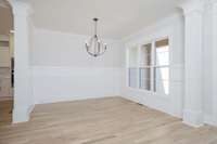 Formal dining room with triple windows and wainscotting.