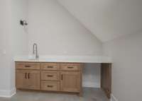 Wet bar in bonus room with tile floor at base.  Room to add your own beverage center.