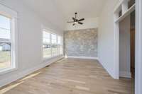 Stone accent wall in sunny gathering area along rear of kitchen.  Home can accommodate lots of visitors.