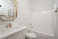 Downstairs Hall bath room for visitors.  Bath has Quartz tops and Gold plumbing accents