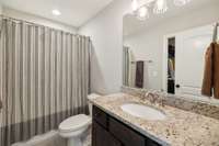 The private Bath features tile flooring, vanity with granite countertop, shower/tub combo, and walk-in closet.