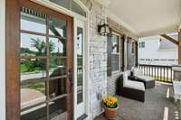 Who doesn't love a Covered Front Porch? Features include a painted wood ceiling, wood railing, lantern-style lighting, and space for rocking chairs or bistro table and chairs.